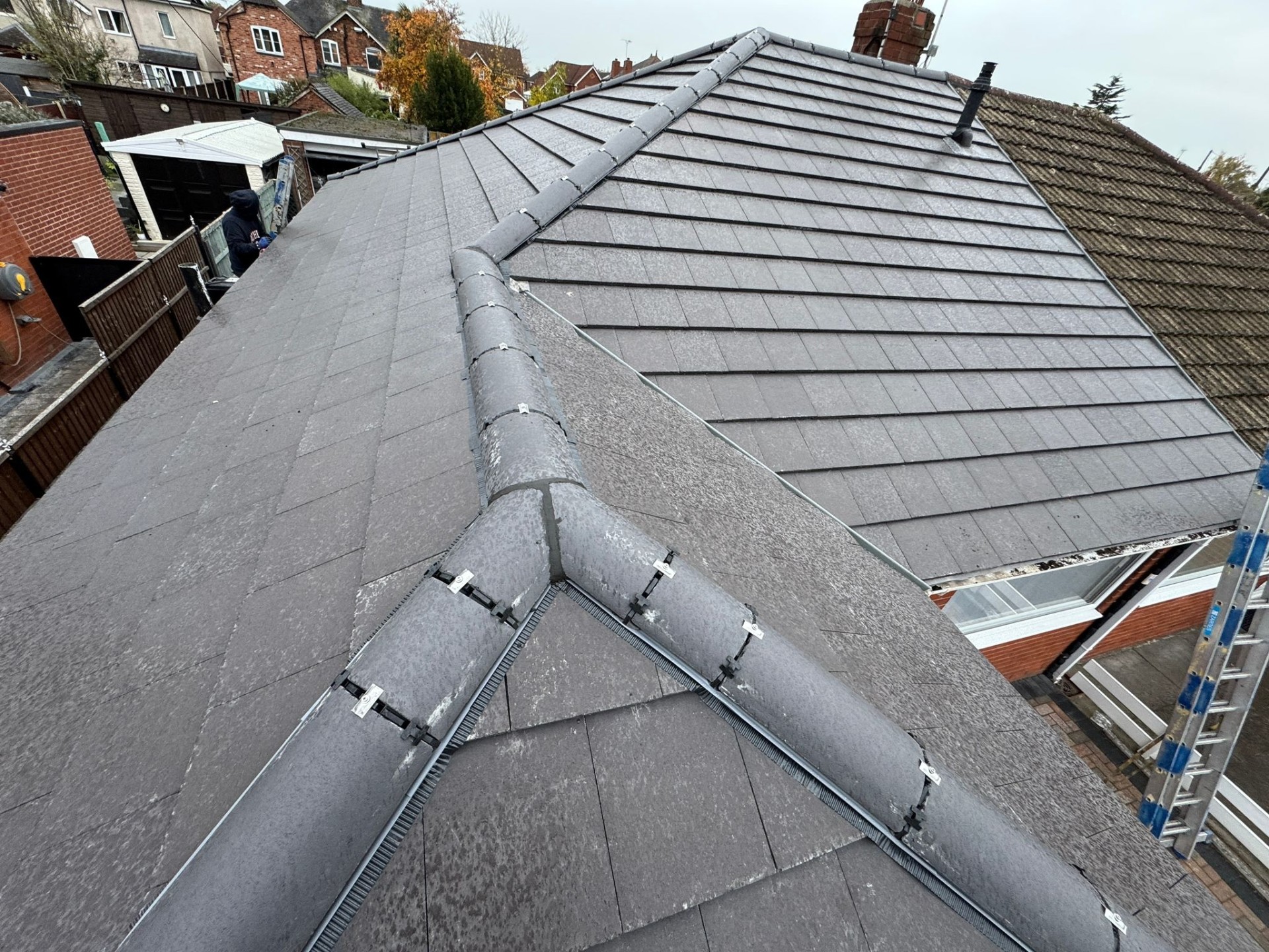 Close-up of completed slate roof with dry-fix ridge system and hip junction