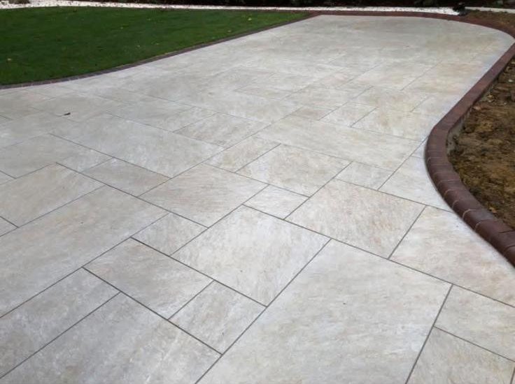Cream porcelain pathway with red brick edge curving along a lawn
